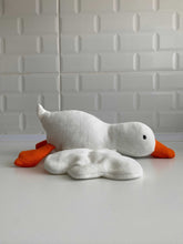 Handmade white goose plush toy with orange beak and feet sitting on flat surface